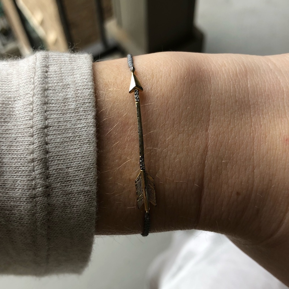 Dainty gold arrow bracelet with light gray rope